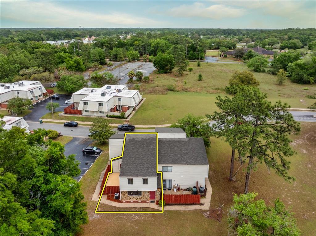 An aerial view shows a two-story townhouse with a stone facade and fenced patio — 2134 NE 45TH AVENUE, OCALA, FL