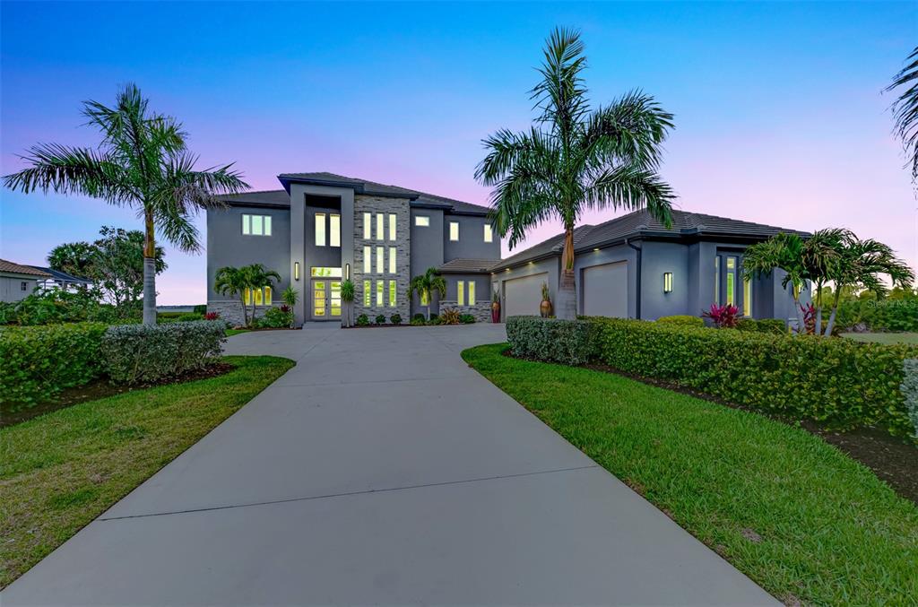 An aerial view of a two-story gray house with a tiled roof and stone accents — 3051 RIVERSHORE LANE, PORT CHARLOTTE, FL