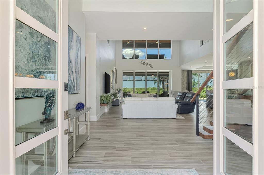 A view from an entryway into a living room with high ceilings and tile floors — 3051 RIVERSHORE LANE, PORT CHARLOTTE, FL