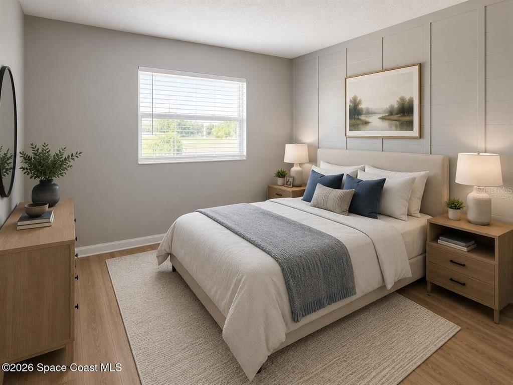 A bedroom features a bed with blue pillows, a wood dresser, and board-and-batten wall paneling — 50 NEEDLE BOULEVARD UNIT 6, MERRITT ISLAND, FL