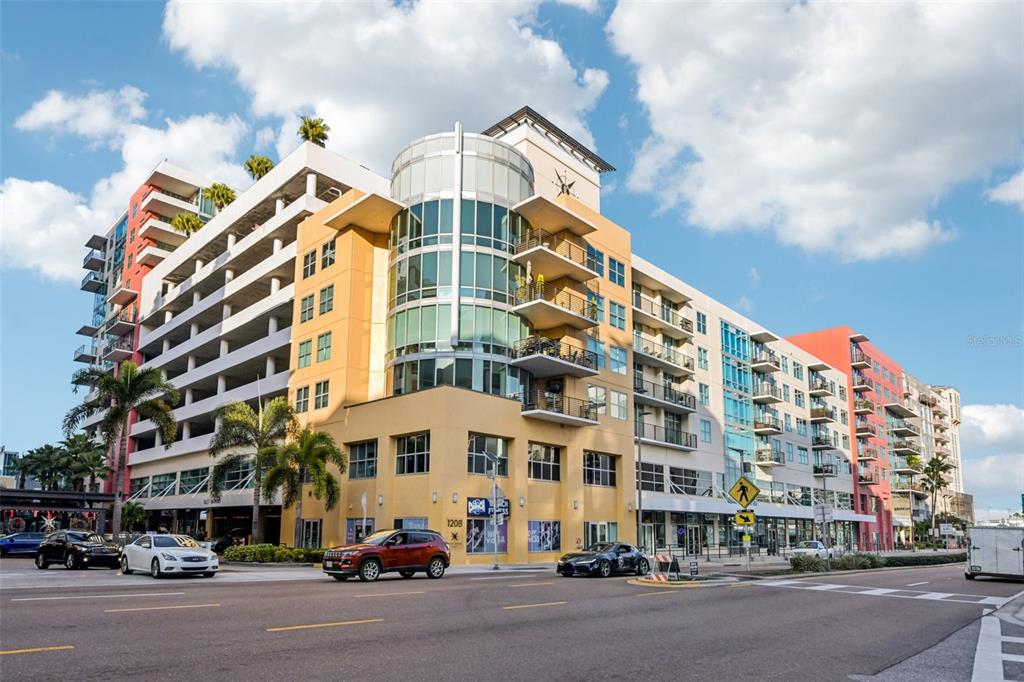 A multi-story building with a curved glass corner, balconies, and a parking garage exterior — 1208 E KENNEDY BOULEVARD UNIT 616, TAMPA, FL