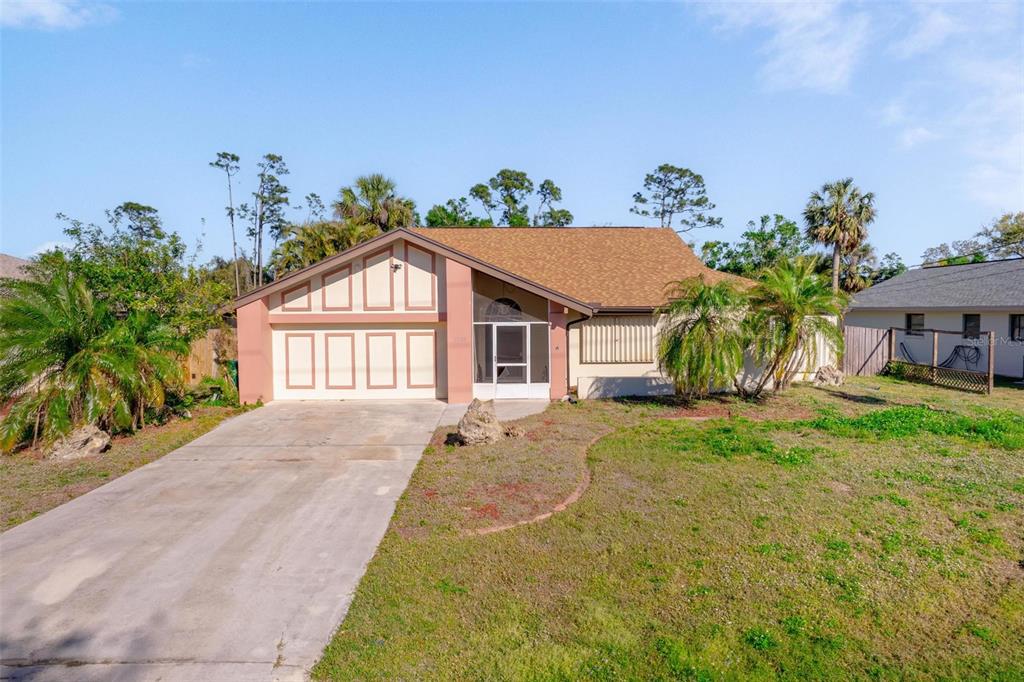 A single-story house with a tan exterior, a two-car garage, and a front driveway — 1224 INVERNESS STREET, PORT CHARLOTTE, FL