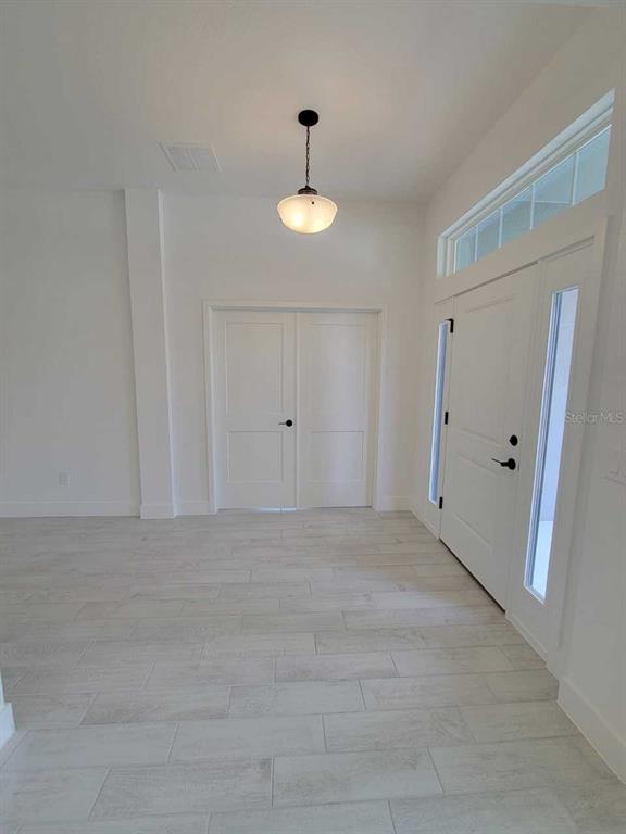 An entryway features light-colored tile flooring, a pendant light, and a white double-door entrance — 4626 SW 103RD STREET ROAD, OCALA, FL
