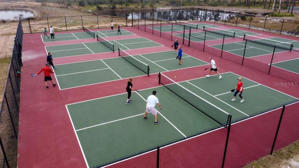 An aerial view shows several people playing pickleball on outdoor courts with green surfaces — 33 TIKI TURN HYW 630 E, LAKE WALES, FL