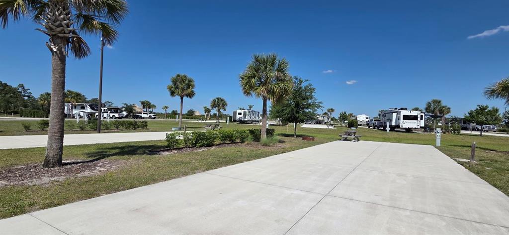 A concrete RV pad sits in a sunny, landscaped outdoor park with palm trees — 33 TIKI TURN HYW 630 E, LAKE WALES, FL