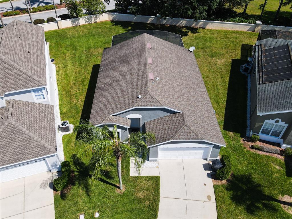An aerial view shows a single-story house with a shingled roof and a driveway — 8050 KING PALM CIRCLE, KISSIMMEE, FL