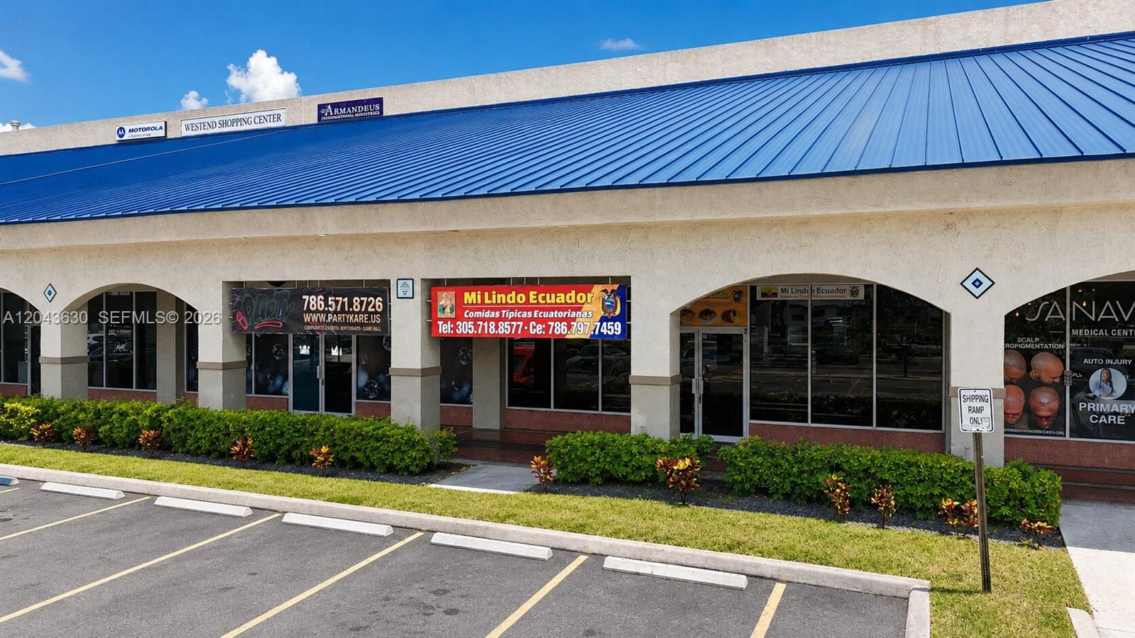 The exterior of a strip mall features a blue metal roof and several storefronts — 8726 NW 26 ST # 18, Doral FL 33172, DORAL, FL