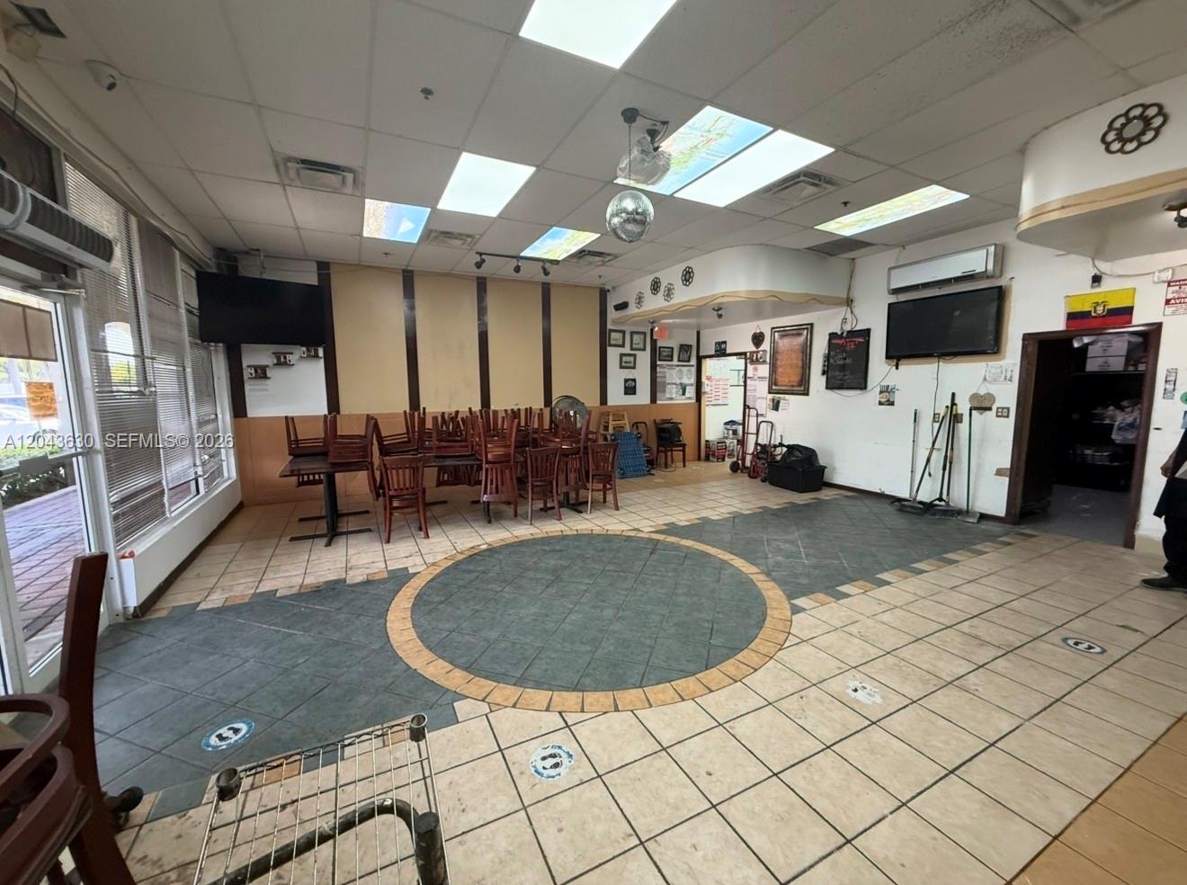 An interior view of a commercial space featuring tiled floors, tables, chairs, and a disco ball — 8726 NW 26 ST # 18, Doral FL 33172, DORAL, FL