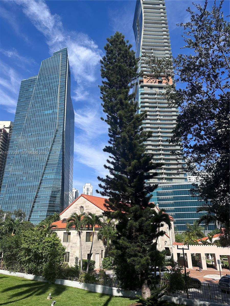 A tall pine tree stands in front of a historic building flanked by two modern skyscrapers — 1541 Brickell Ave # B403, Miami FL 33129, MIAMI, FL