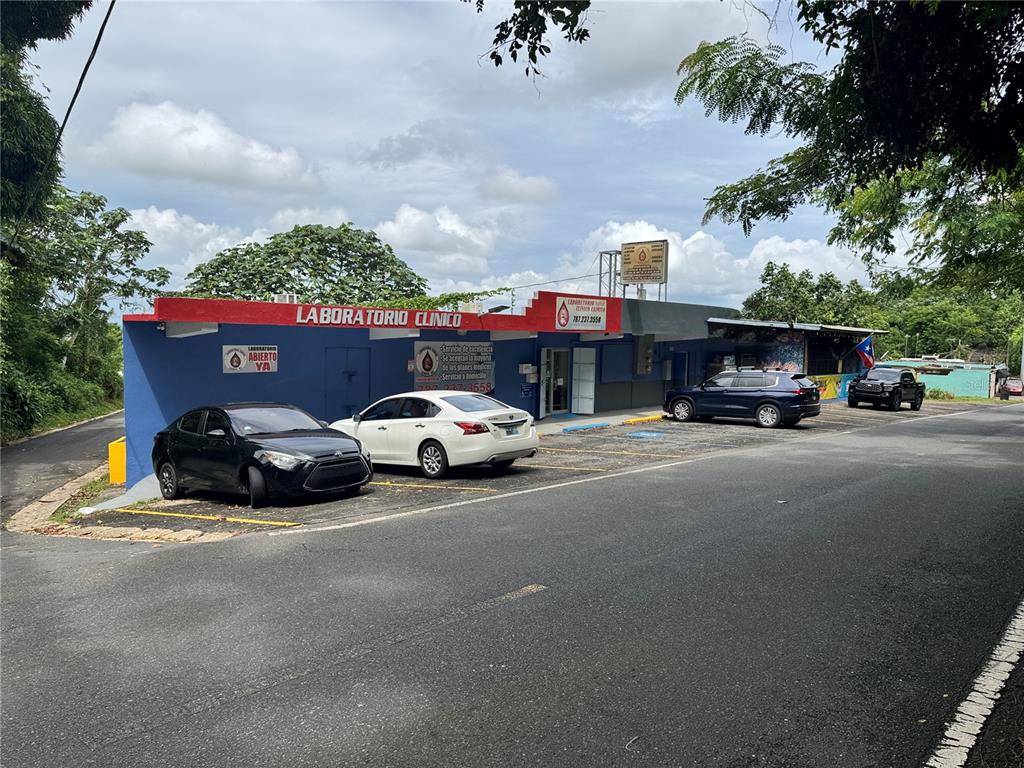 A clinical laboratory building with a blue facade and parking lot under a cloudy sky — 842 N CAMINO LOS MURIELES, SAN JUAN, PR