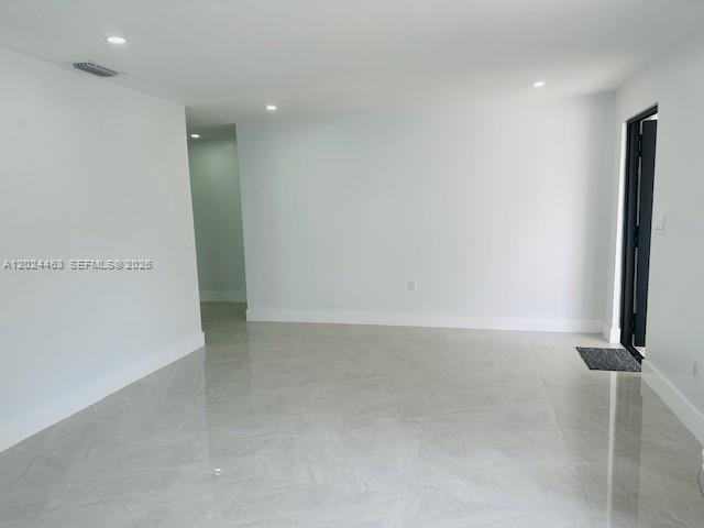 An empty room features white walls, recessed lighting, and light-colored tile flooring — 11870 SW 5th # 1, Miami FL 33184, MIAMI, FL