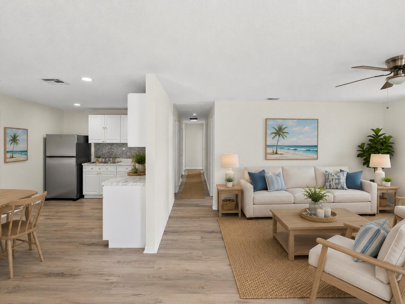 An open-concept living room and kitchen area with light wood floors and coastal decor — 2575 1st Place, Vero Beach FL 32962, VERO BEACH, FL