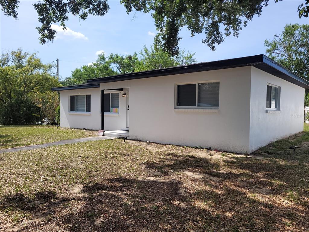 A single-story white house with a flat roof and a small front porch — 105 FOREST PARK AVENUE, TEMPLE TERRACE, FL