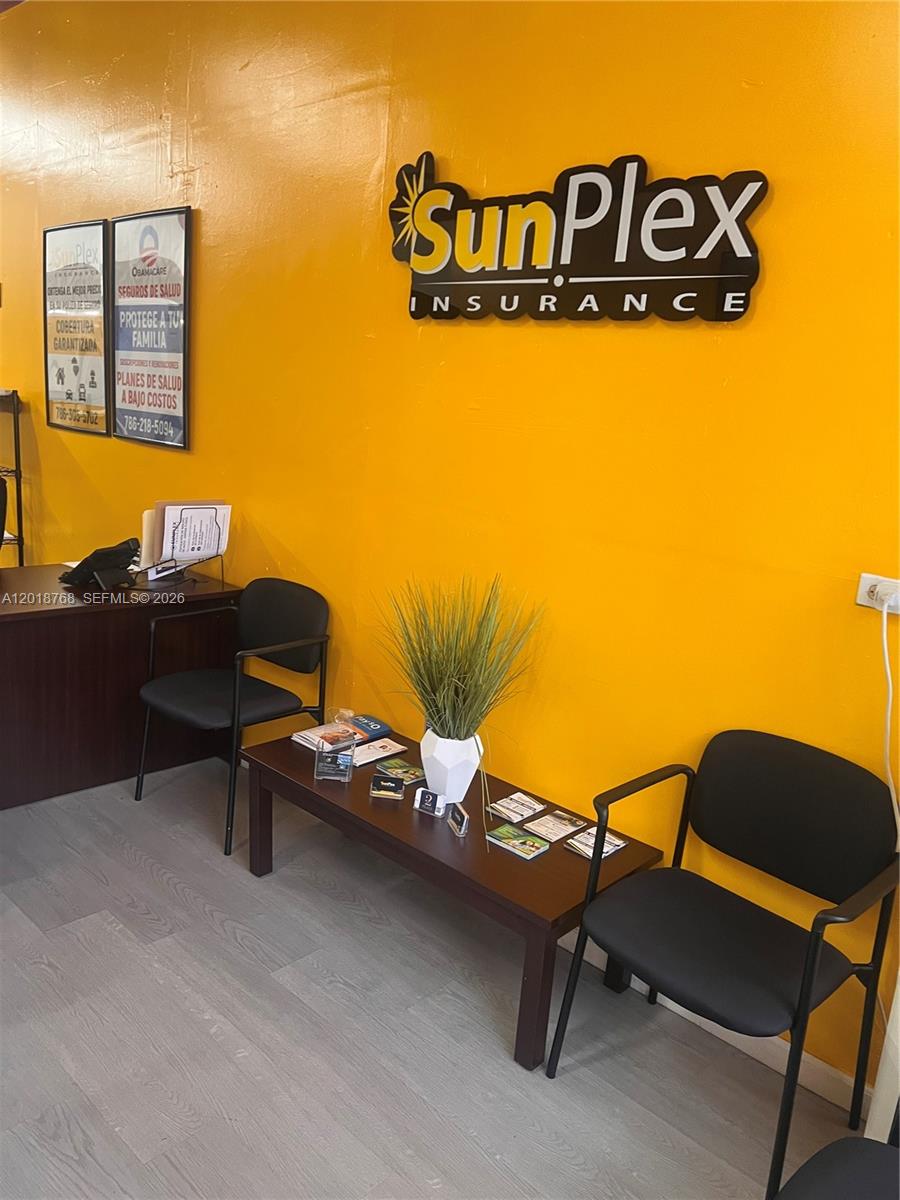 An office waiting area features yellow walls, a SunPlex Insurance sign, and black chairs — 402 NW 27 Ave, Miami FL 33125, MIAMI, FL