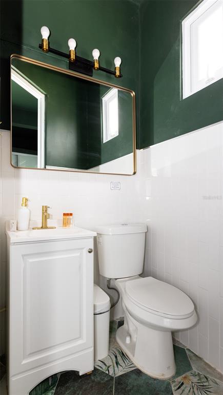 A bathroom features a white vanity, a toilet, a gold-framed mirror, and dark green walls — 9 CALLE DEL MERCADO, SAN JUAN, PR
