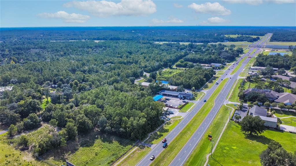 An aerial view shows a multi-lane highway running past a wooded area and commercial buildings — 4164 W GULF TO LAKE HIGHWAY, LECANTO, FL