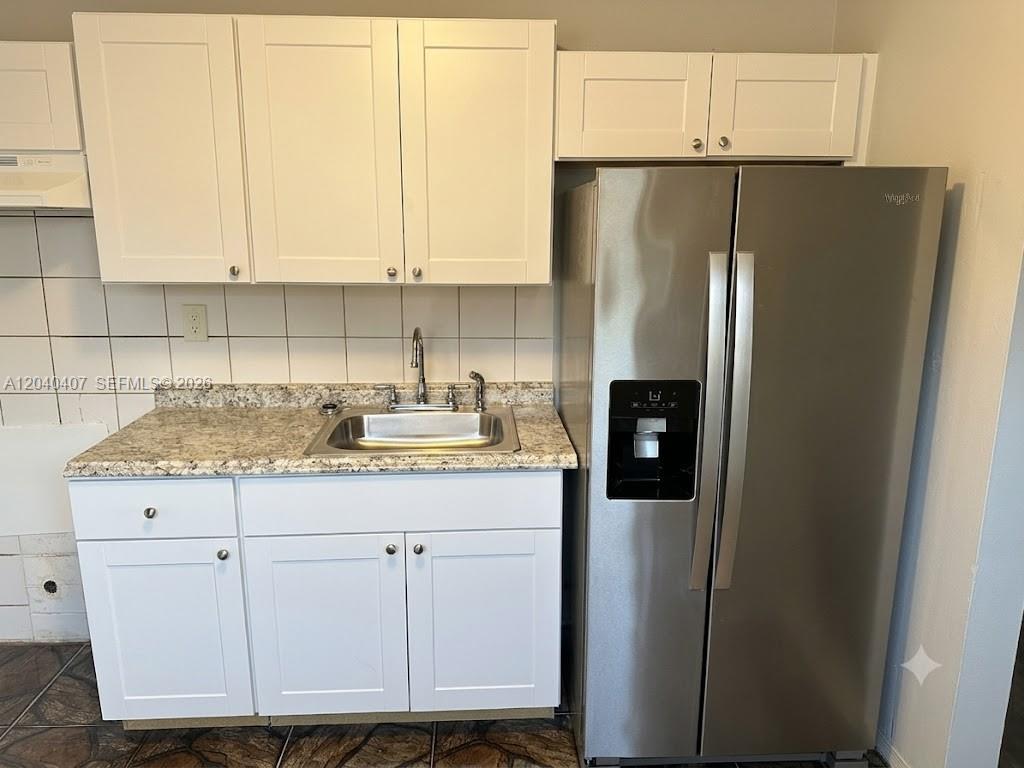 A kitchen features white cabinets, a granite countertop, a stainless steel sink, and a refrigerator — 820 NW 4th Ave, Fort Lauderdale FL 33311, FORT LAUDERDALE, FL