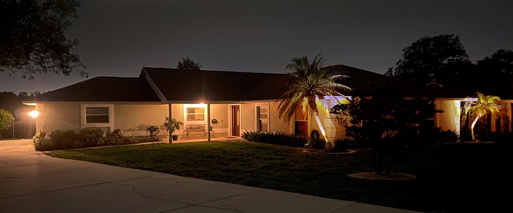 A single-story house with a lit porch and palm trees at night — 2624 TUSCARORA TRAIL, MAITLAND, FL