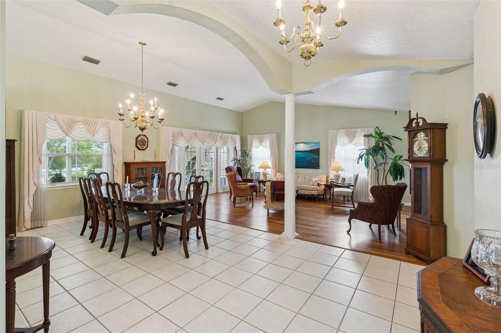 A living room and dining area with hardwood floors, a white column, and lake views — 2624 TUSCARORA TRAIL, MAITLAND, FL