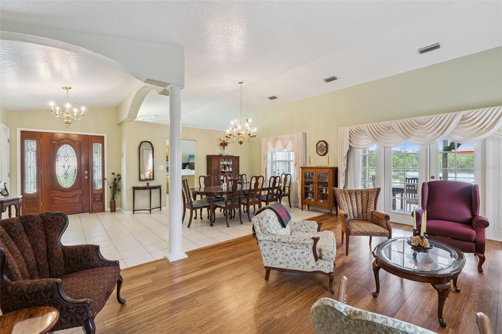 A living room features a stone fireplace, tile flooring, a ceiling fan, and a dining area — 2624 TUSCARORA TRAIL, MAITLAND, FL