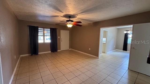 A living room with beige walls, tile flooring, a ceiling fan, and an adjacent dining area — 4407 N SUWANEE AVENUE, TAMPA, FL