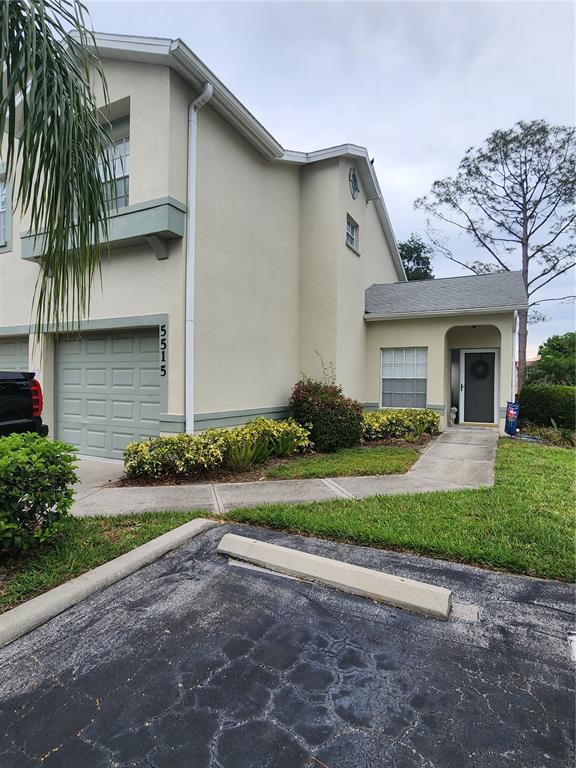 A two-story townhouse exterior features a garage, a front entrance, and a landscaped yard — 5515 FAIR OAKS STREET UNIT 5515, BRADENTON, FL
