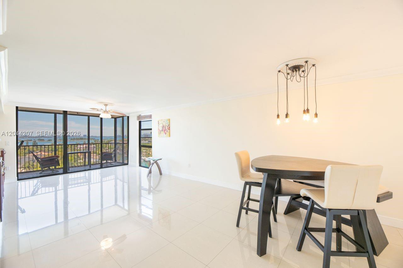 A dining area with a dark table and chairs sits on white tile floors — 2500 NE 135th St # C1011, North Miami FL 33181, NORTH MIAMI, FL