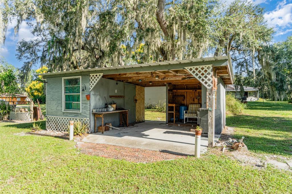 A small, open-sided shed with a concrete floor, a workbench, and a metal roof — 918 W MAGNOLIA STREET, ARCADIA, FL