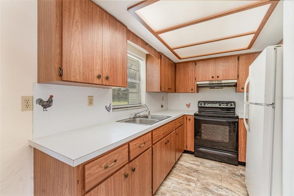 A kitchen features wood cabinets, white countertops, a black stove, and a white refrigerator — 918 W MAGNOLIA STREET, ARCADIA, FL