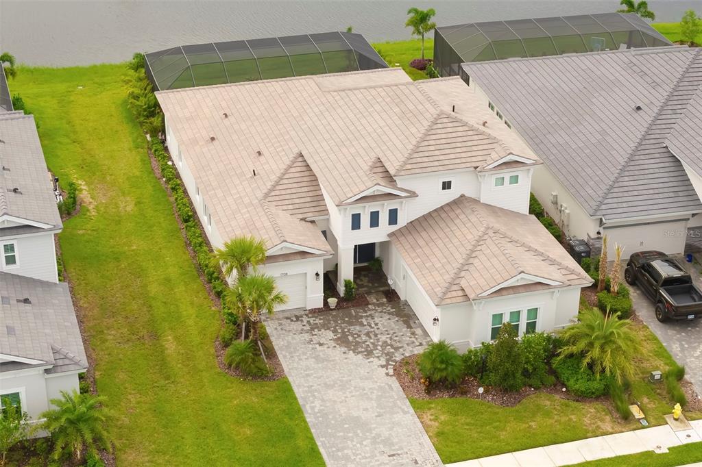 An aerial view shows a white house with a tiled roof and a paved driveway — 17128 RANCHSIDE PLACE, LAKEWOOD RANCH, FL