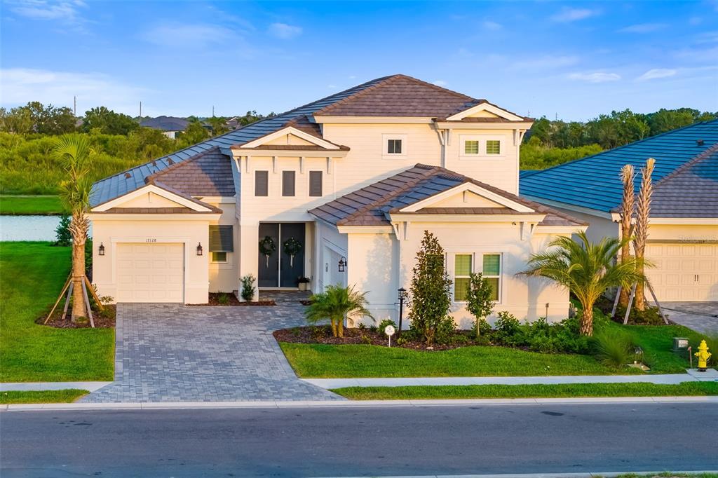 A two-story suburban house with a paved driveway, tiled roof, and landscaped front yard — 17128 RANCHSIDE PLACE, LAKEWOOD RANCH, FL