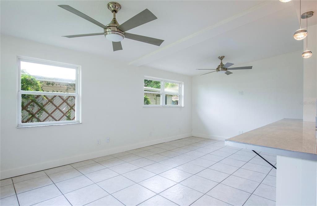 A bright room with white walls, tiled floors, two ceiling fans, and two windows — 10276 121ST AVENUE, LARGO, FL