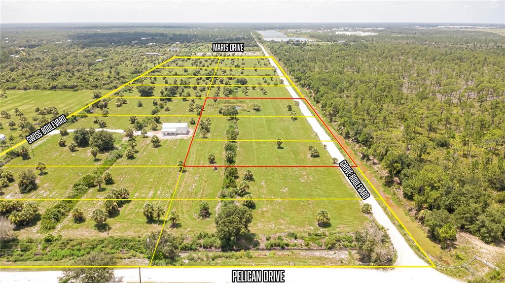 An aerial view shows a large, grassy plot of land outlined in yellow and red — 7074 GROVE BOULEVARD, PUNTA GORDA, FL