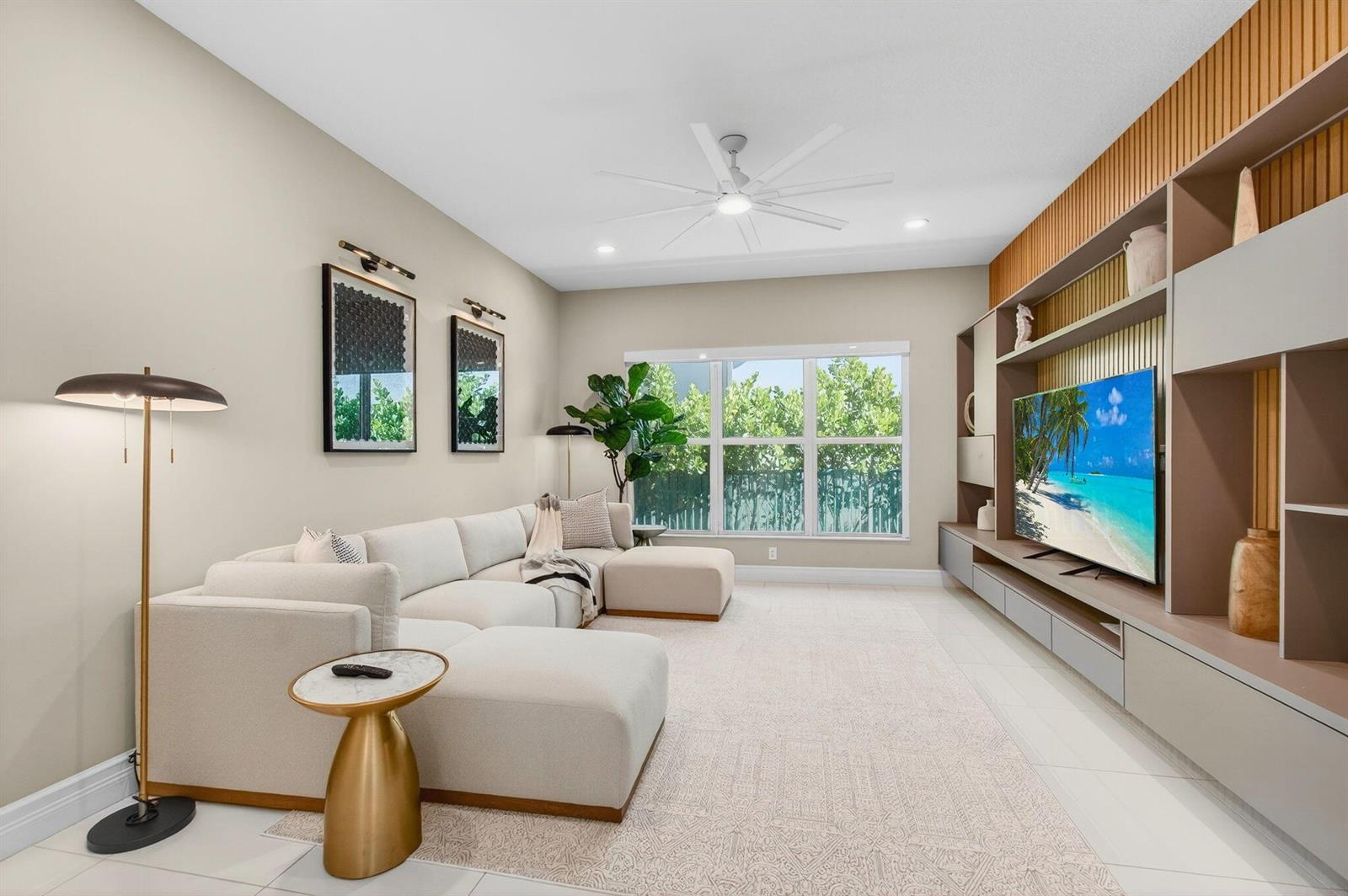 A modern living room features a large sectional sofa, a wall-mounted television, and built-in shelving — 19886 Meadowside Lane Lane, Boca Raton FL 33498, BOCA RATON, FL