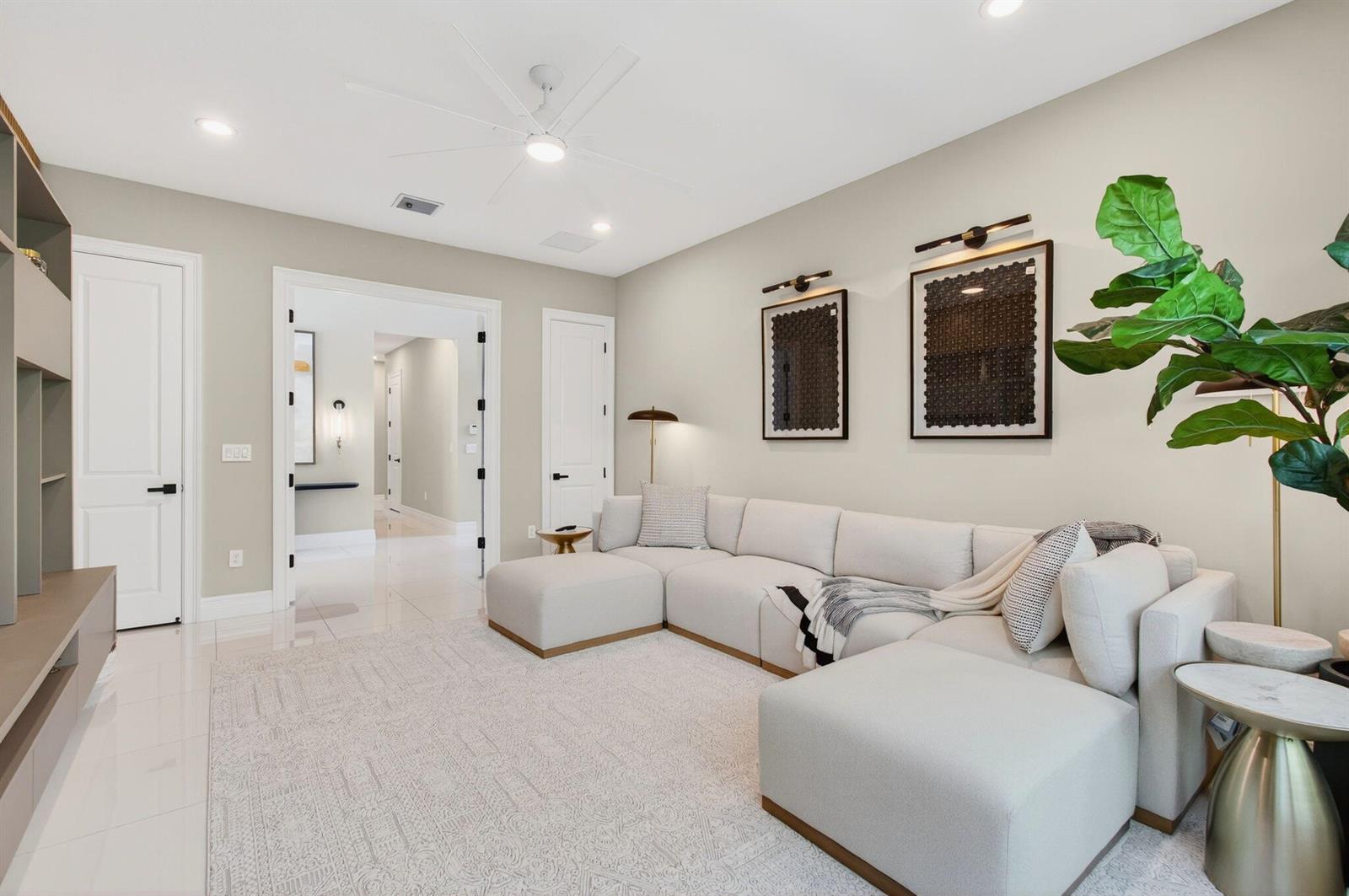 A modern living room features a large beige sectional sofa, a patterned rug, and wall art — 19886 Meadowside Lane Lane, Boca Raton FL 33498, BOCA RATON, FL