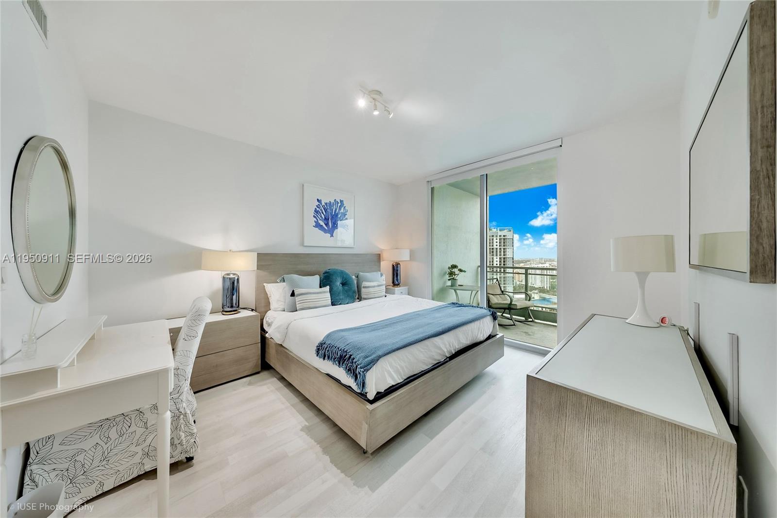 A modern bedroom features a bed, desk, and balcony with a view of city buildings — 90 SW 3rd St # 3109, Miami FL 33130, MIAMI, FL