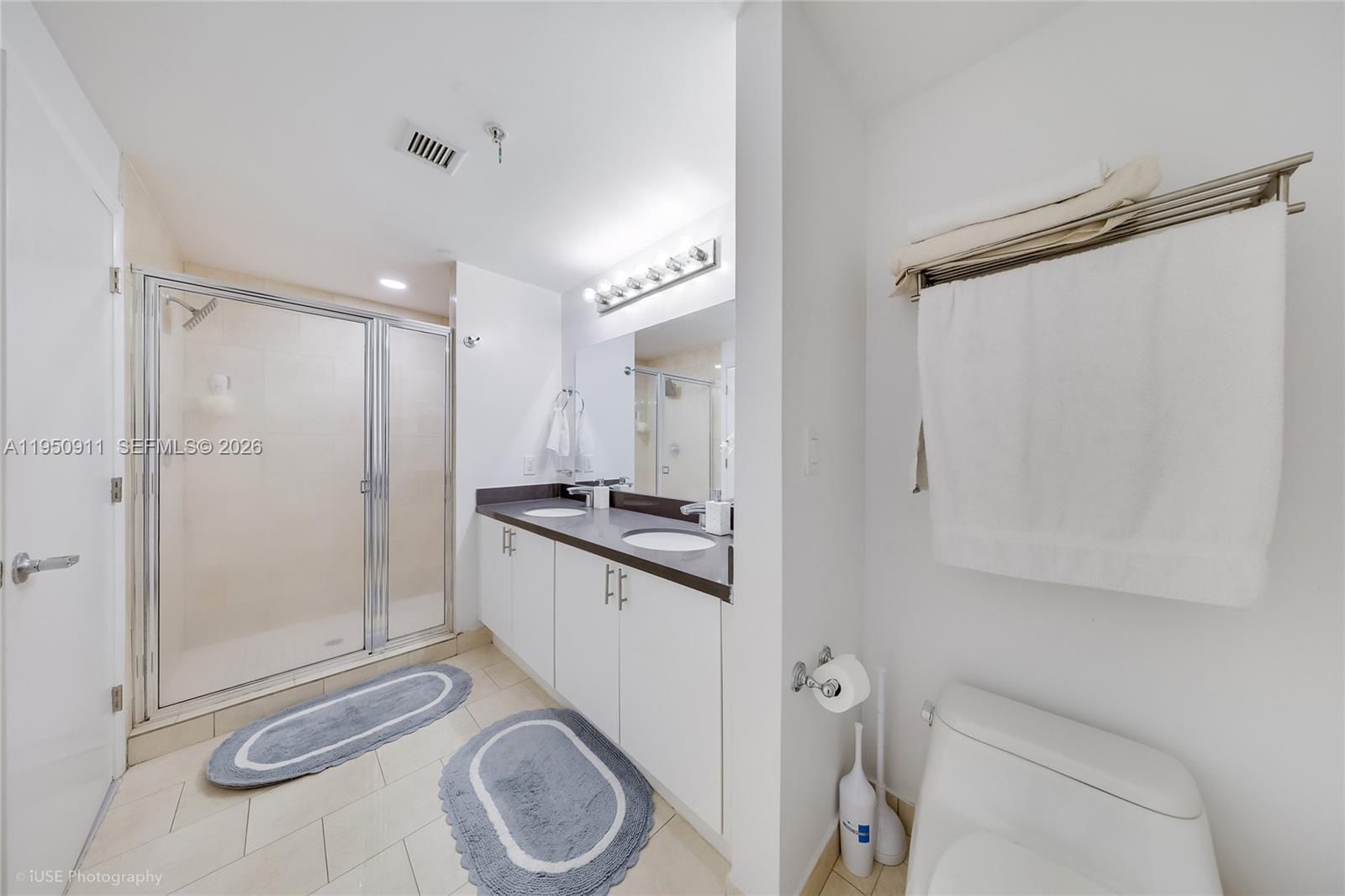 A bathroom features a glass-enclosed shower, a double vanity with white cabinets, and a toilet — 90 SW 3rd St # 3109, Miami FL 33130, MIAMI, FL