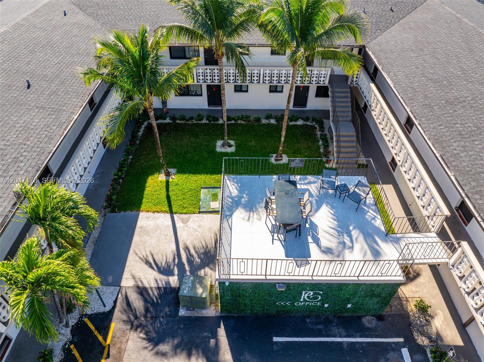 An aerial view shows a courtyard with palm trees, a patio, and apartment buildings — 1330 W 29th St # 9, Hialeah FL 33012, HIALEAH, FL