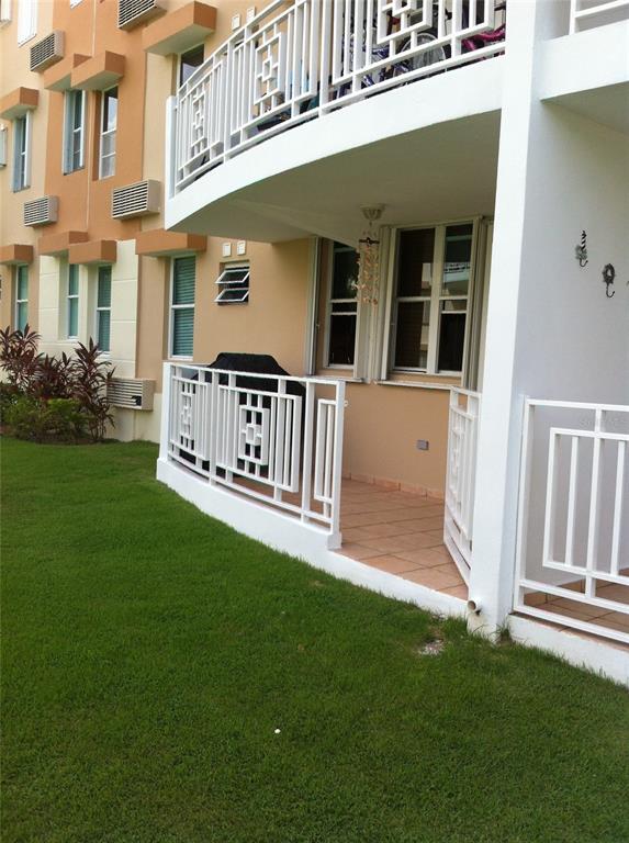A ground-floor apartment patio with white railings, tile flooring, and a black grill — II LOS PARILLAS UNIT 3501, LOIZA, PR