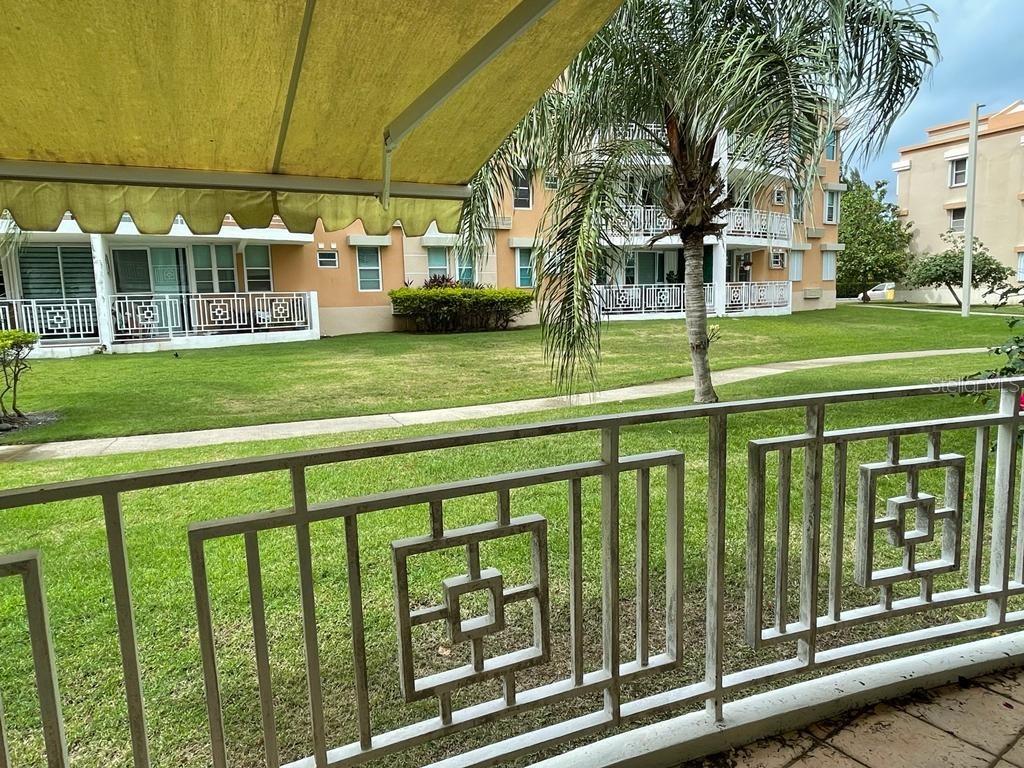 A view from a balcony with a metal railing overlooking a grassy courtyard and apartments — II LOS PARILLAS UNIT 3501, LOIZA, PR