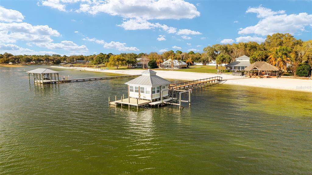 An aerial view shows a boat house on a dock extending into a lake — 14261 SE 128TH STREET, OCKLAWAHA, FL