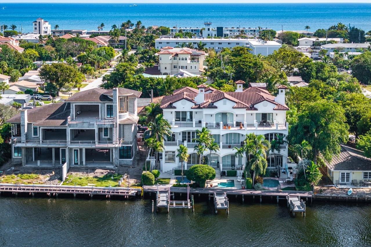 An aerial view shows a finished white multi-story house next to a house under construction — 549 NE 19th Avenue # C, Deerfield Beach FL 33441, DEERFIELD BEACH, FL