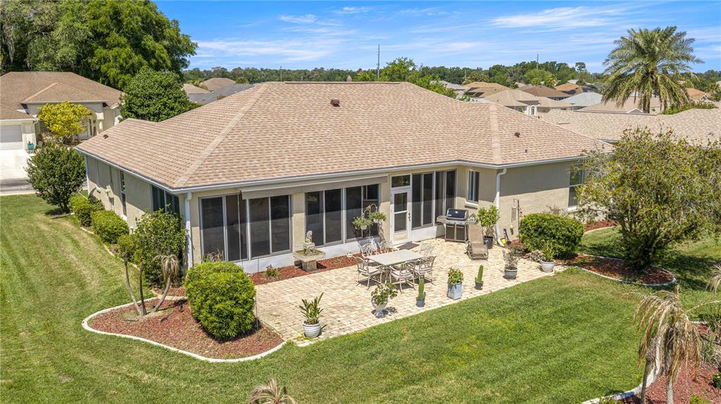 An aerial view shows a house with a screened-in porch and a paved patio area — 2081 NW 58TH COURT, OCALA, FL