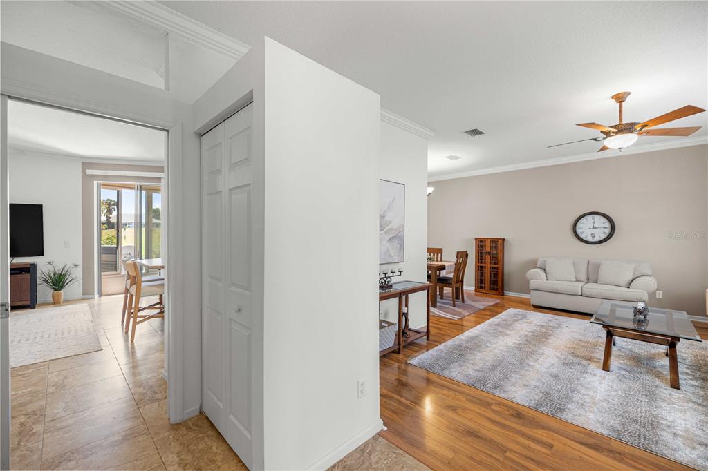 A living room with wood flooring, a beige sofa, and an adjacent dining area — 2081 NW 58TH COURT, OCALA, FL