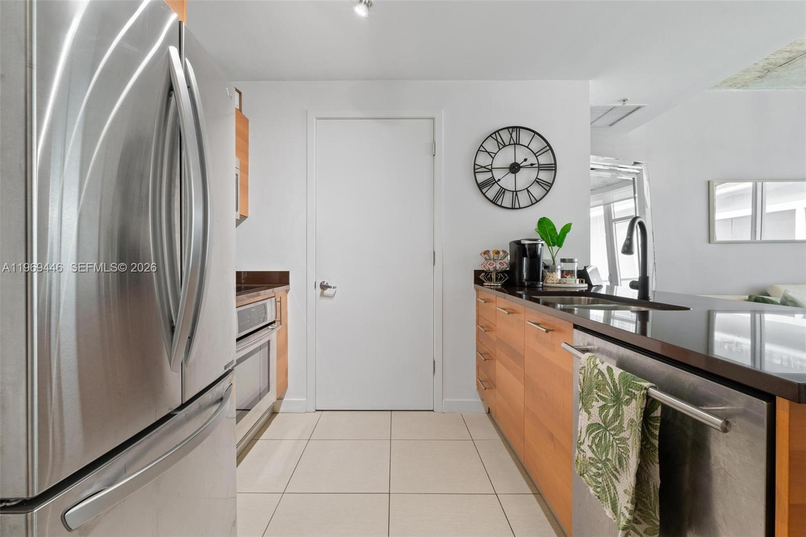 A kitchen features stainless steel appliances, wood cabinets, and a black countertop — 3301 NE 1st Ave # L0304, Miami FL 33137, MIAMI, FL