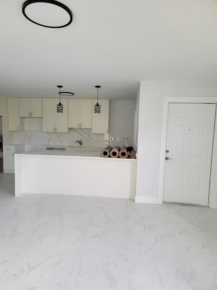 A kitchen with white cabinets, marble-patterned countertops, and matching tile flooring — 240 SW 7th Street # 9, Boca Raton FL 33432, BOCA RATON, FL