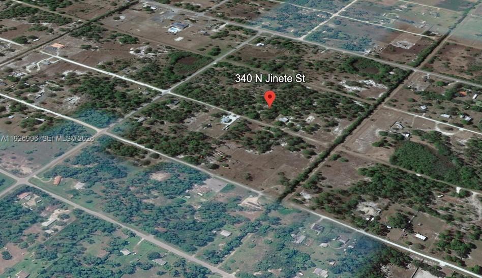 An aerial view shows a wooded residential lot with a red location pin — 340 N Jinete ST, Clewiston FL 33440, CLEWISTON, FL