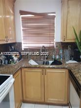 A kitchen features light wood cabinets, a stainless steel sink, and brown speckled countertops — 8089 NW 8th St # 3, Miami FL 33126, MIAMI, FL