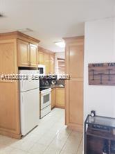 A kitchen features light wood cabinets, a white refrigerator, and tile flooring — 8089 NW 8th St # 3, Miami FL 33126, MIAMI, FL