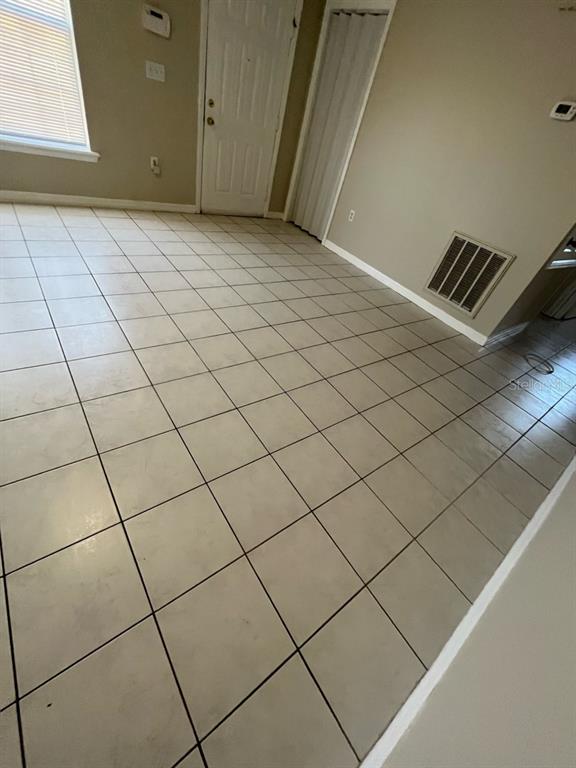 An interior room features light-colored square floor tiles, a white door, and a wall vent — 1830 2ND STREET NW UNIT B, WINTER HAVEN, FL
